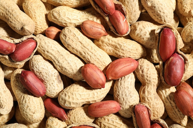 many fresh unpeeled peanuts as background top view