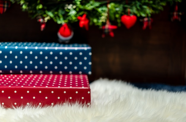 Many gift boxes colorful of present paper placed on white fluffy carpet at the end of bed.