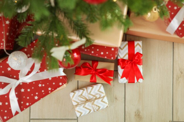 밝은 실내에서 축제로 장식된 크리스마스 트리 아래 많은 선물