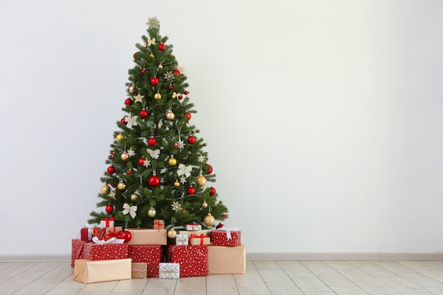 Many gifts under a festively decorated christmas tree in a bright interior