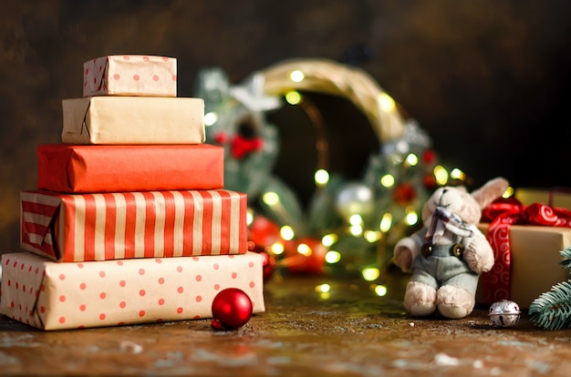 Many gifts in Wrapping Paper craft and homemade gingerbread house, lights bokeh on dark background,