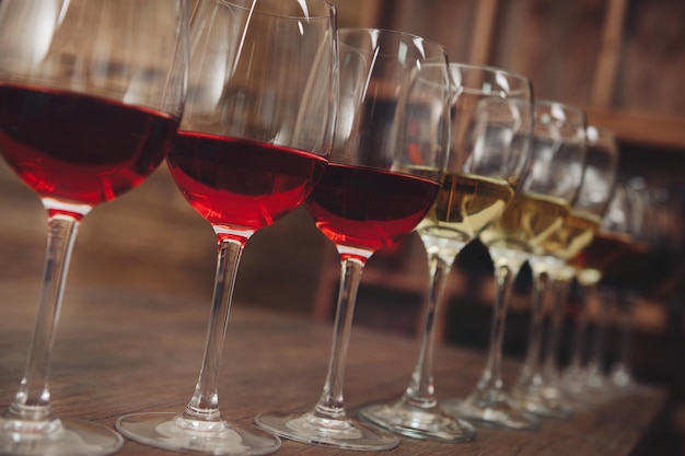 Many glasses of different wine in a row on bar counter