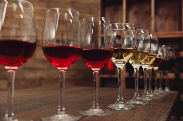 Many glasses of different wine in a row on bar counter