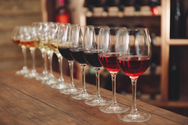 Many glasses of different wine in a row on bar counter