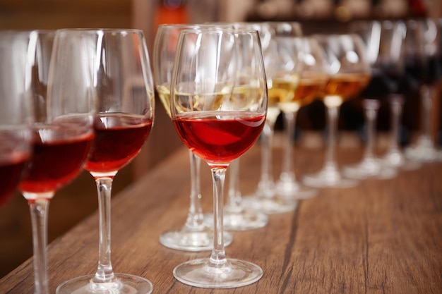 Many glasses of different wine in a row on bar counter