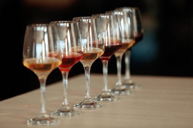 Many glasses of different wine in a row on a table