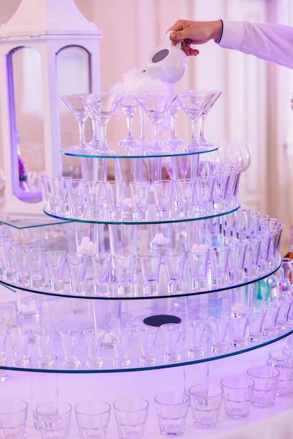 休日にさまざまな飲み物を準備するためのピラミッド型のスタンドに多くのグラスが立つ