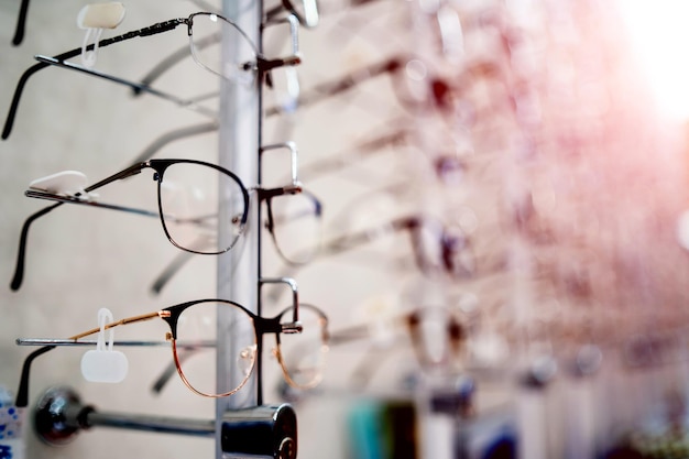 Photo many glasses on a stand showcase with glasses in modern ophthalmic store closeup