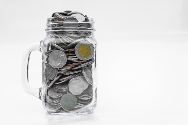 Many gold coins in glass on white background