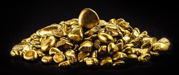 Many gold nuggets on isolated black background, concept of wealth and rare ores