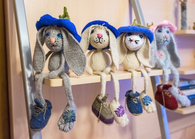 Foto molte lepri tristi lavorate a mano, giocattoli per bambini lavorati a maglia