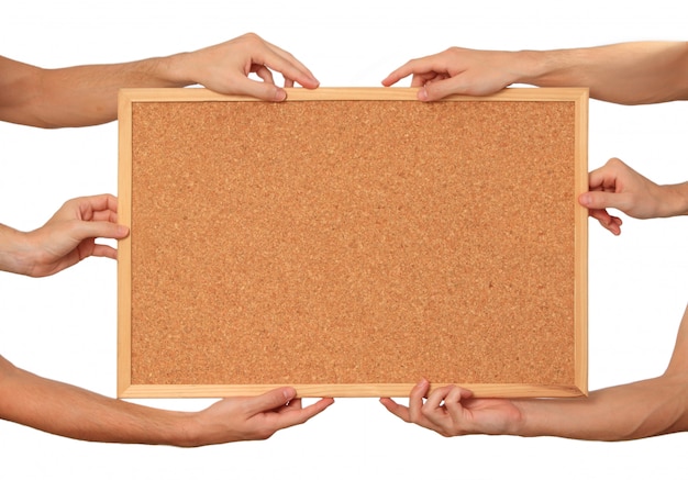 Many hands holding the cork board