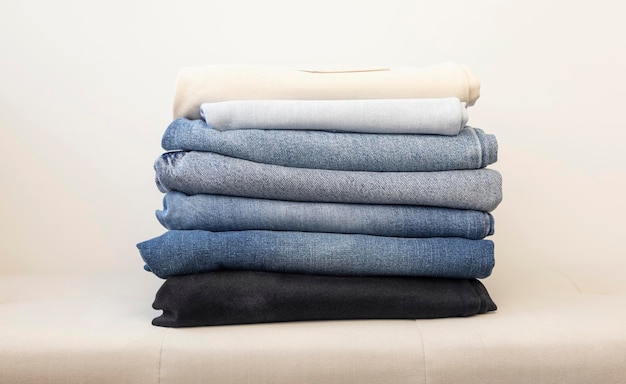 Many jeans stacked on top of each other in different colors Casual clothing concept