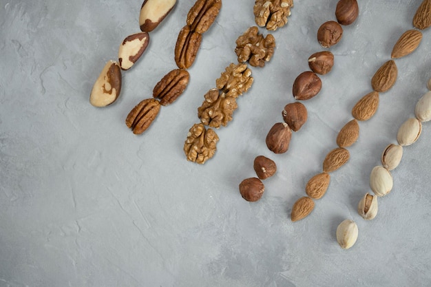 Many kinds of nuts close up. Heap of nuts on a black wooden board. Nuts are stacked on the table.