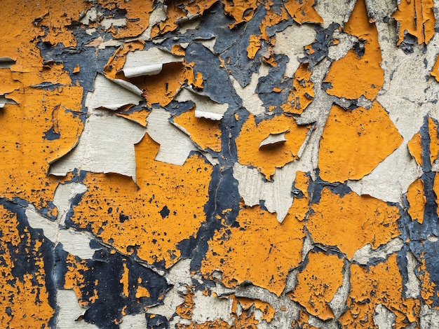 Photo many layers of paint. the old peeling wall is orange