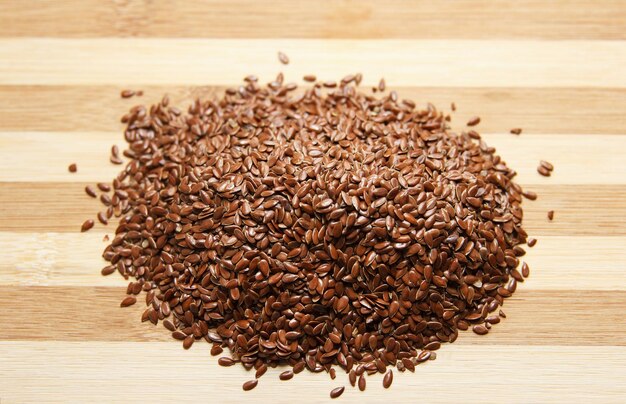 Many linen raw seeds lie on a wooden kitchen board Raw baking ingredient Top view