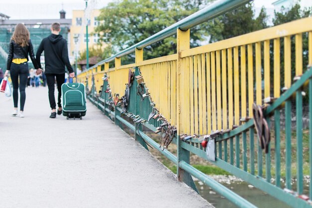 Many locks in the form of a heart on the fence of the bridge