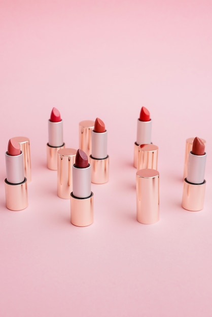 Many luxury gold lipsticks in different shades of pink stand