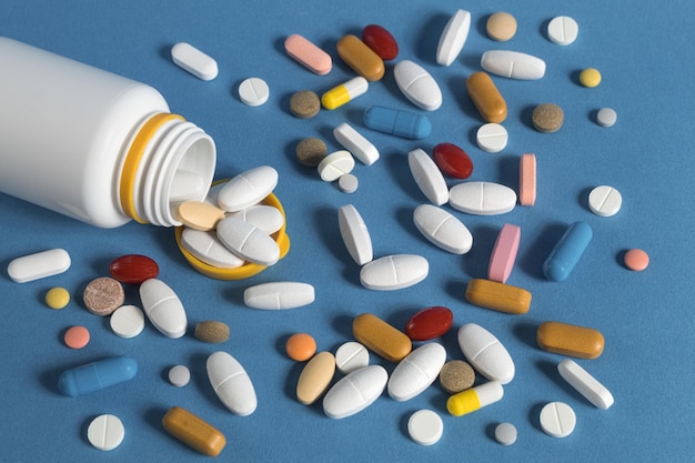 Many medical pills of different colors and shapes scattered closeup