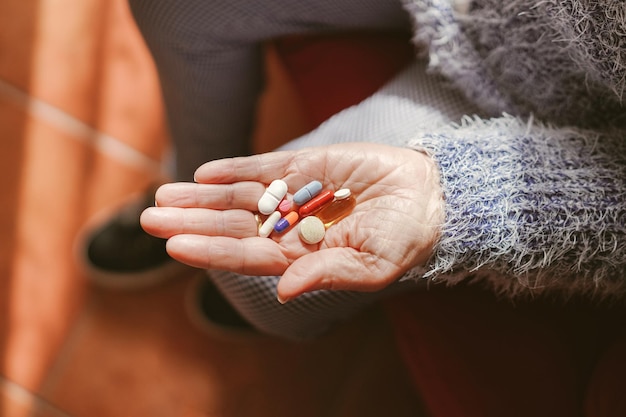 Many medicine pills in the hand of an elderly woman Medicine