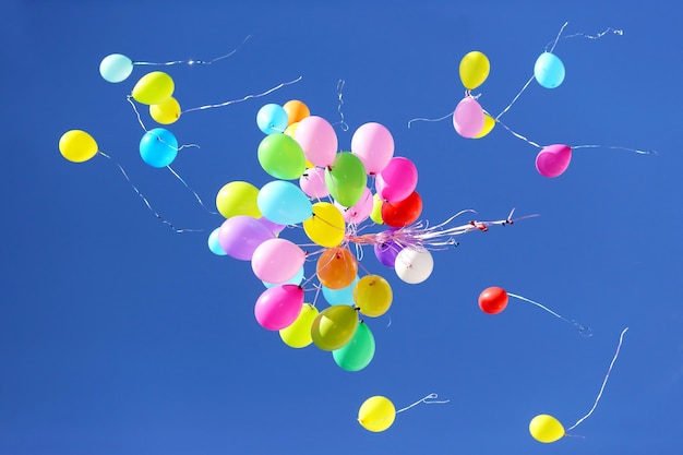 Many multicolored balloons flying in the blue sky. Items to celebrate events