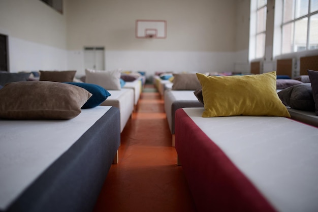 Many multicolored beds with pillows and linens in the interior of the gym