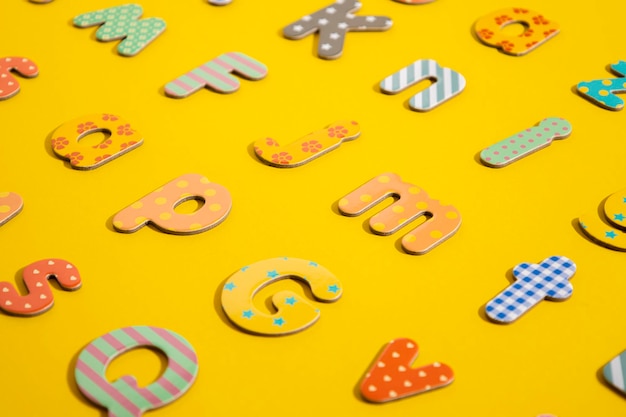 Many multicolored letters of the alphabet on a yellow background