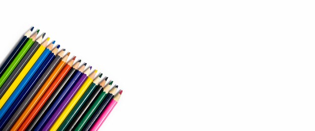 Many multicolored pencils on a white background Top view flat lay Banner