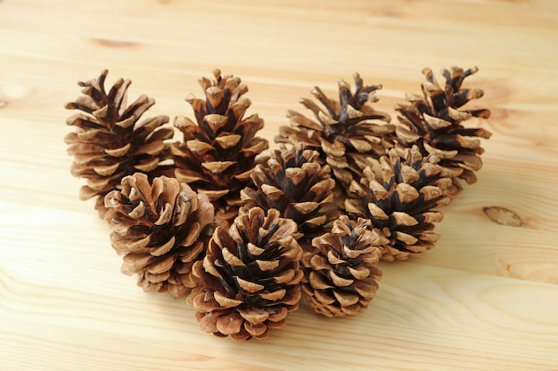 Many Natural Dry Pine Cones Isolated on the Light Brown Wooden Table