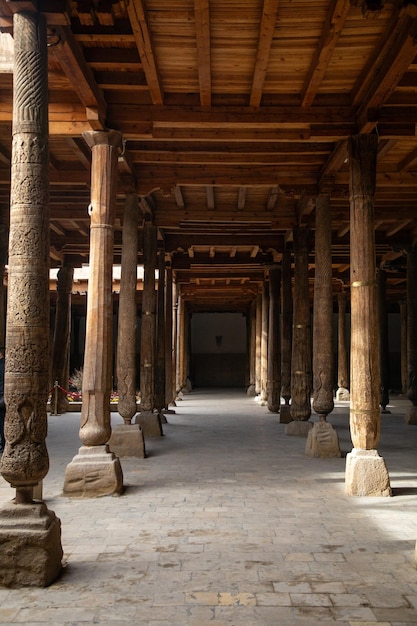 many number of wooden beams with the highly carved in hands inside a historical place Khiva the Khoresm agricultural oasis Citadel