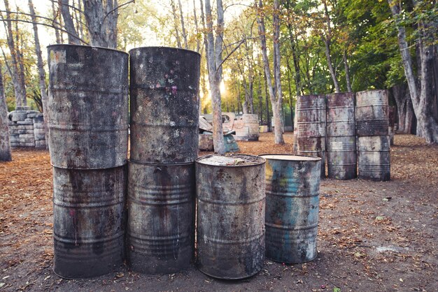 Many old round barrels at the base for playing paintball, behind which th