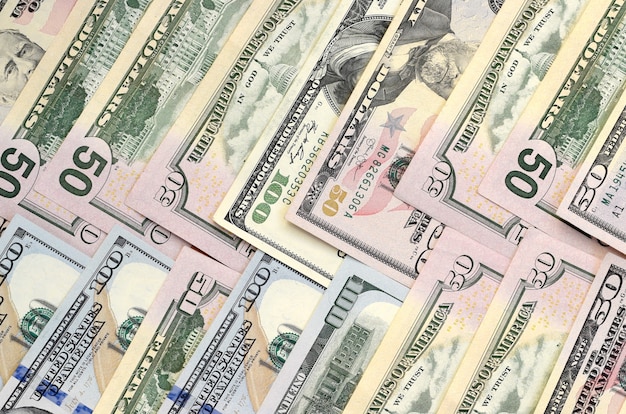 Many one hundred and fifty dollar bills on flat background surface close up. Flat lay top view