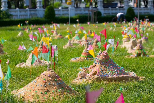 Molte bandiere di carta mettono in un mucchio di sabbia per celebrare un tempio songkran festival in thailandia