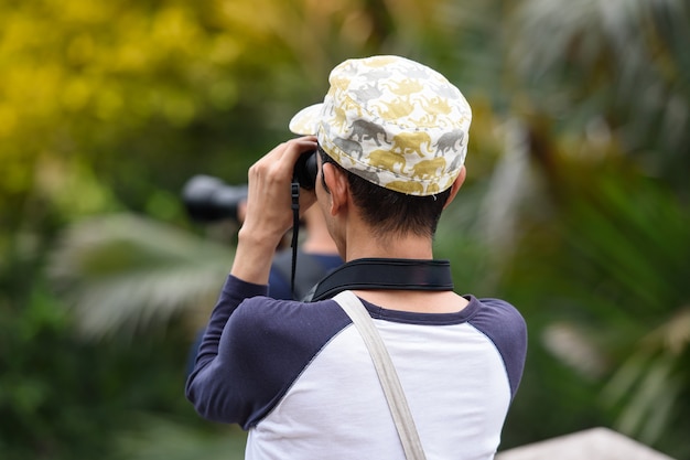 Many people are using cameras to shine something in the park.