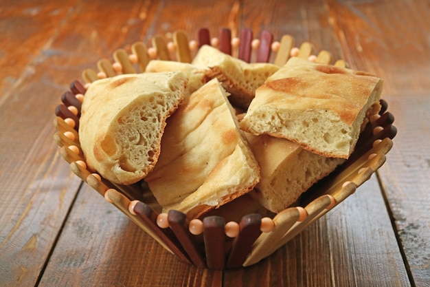 Photo many pieces of cut georgian bread in a basket on wooden table