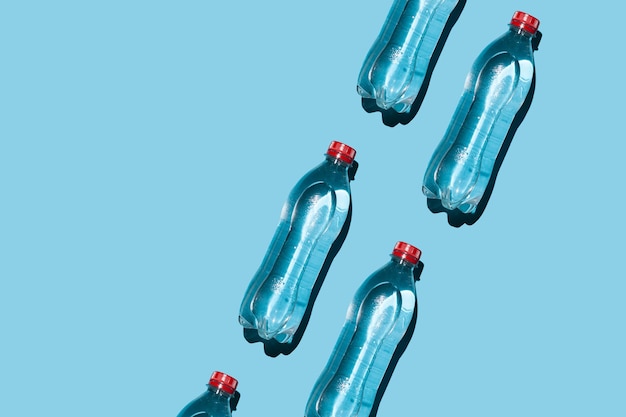 Many plastic water bottles on a blue background