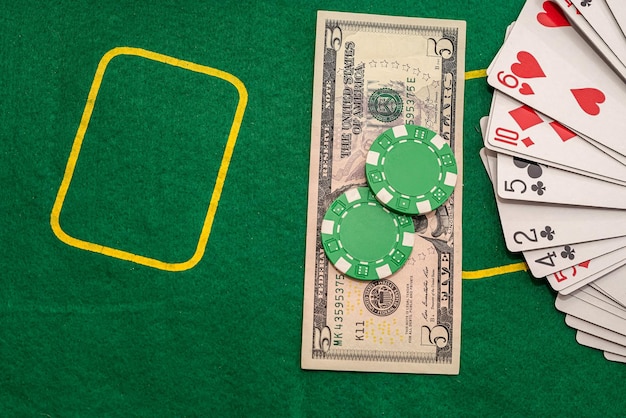 Molte carte da gioco sparse con gettoni colorati e banconote da un dollaro sul tavolo da poker Foto Premium
