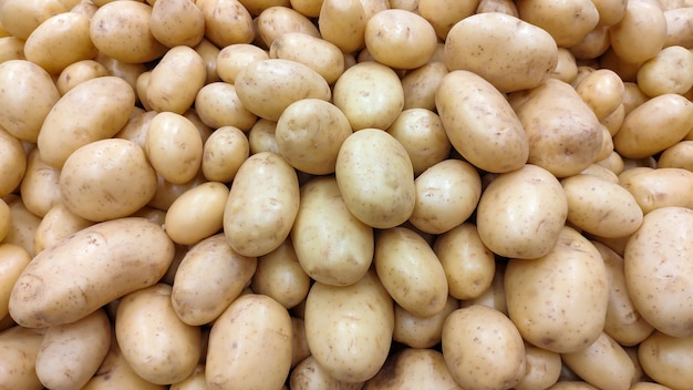 Many potatoes in the supermarket gondola.