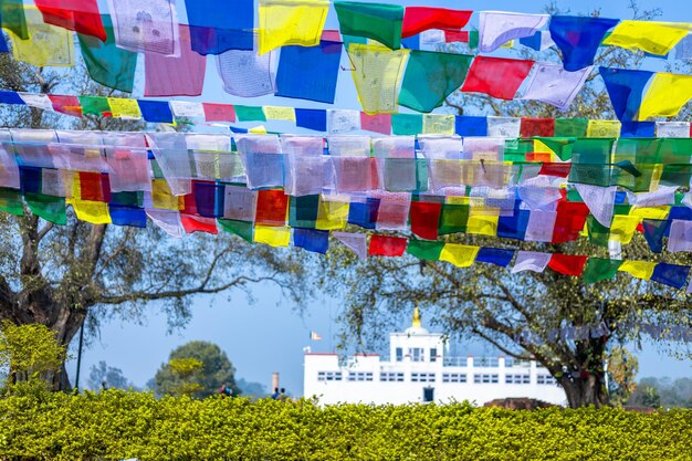 Photo many prayer flags in the wind against the holy maya devi temple in lumbini nepal
