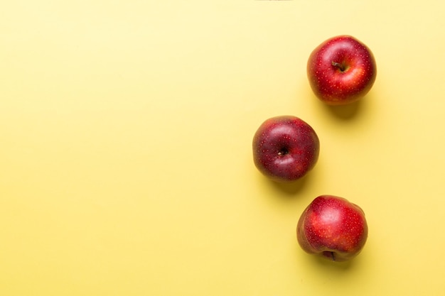 Many red apples on colored background top view Autumn pattern with fresh apple above view with copy space for design or text