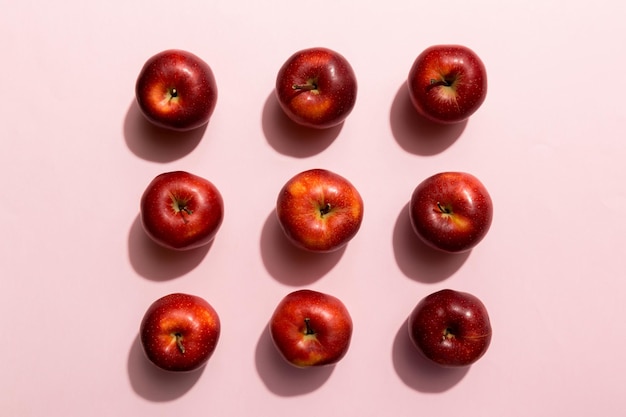 Many red apples on colored background, top view. Autumn pattern with fresh apple above view.