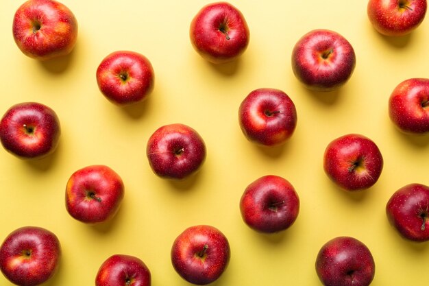 Many red apples on colored background top view Autumn pattern with fresh apple above view