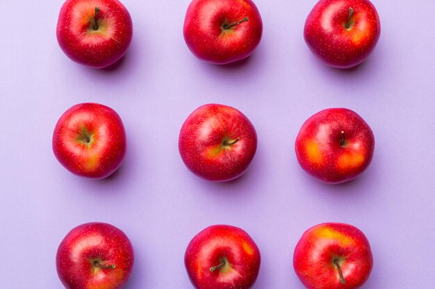 Many red apples on colored background top view autumn pattern with fresh apple above view