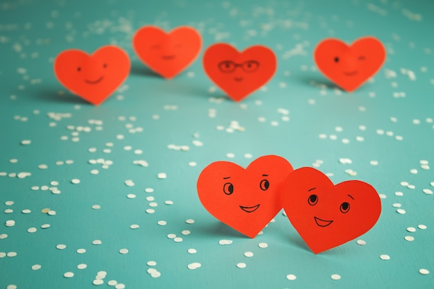 Many red smiling hearts on a blue table. St. Valentine's Day. Couple in love.