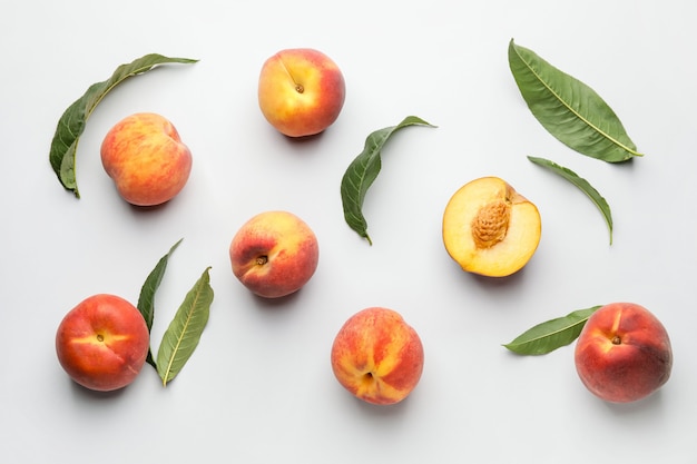 Many ripe peaches on light surface