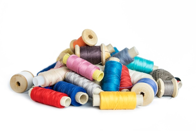 Many sewing threads in different colors on a white isolated 