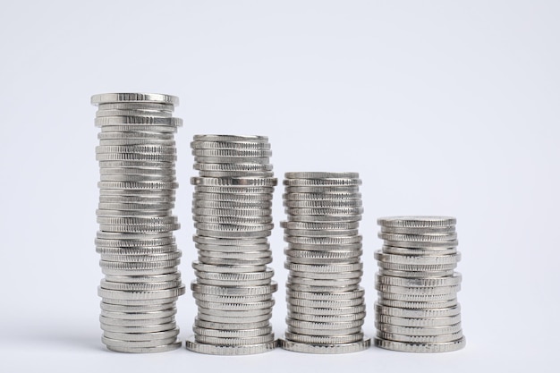 Many silver coins stacked on white background