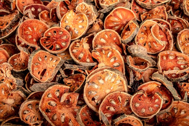 Many of slices of bael fruit for make bael juice, pile of dried bael background