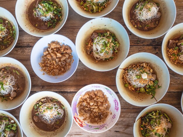 Many small bowls Thai noodle served on table.