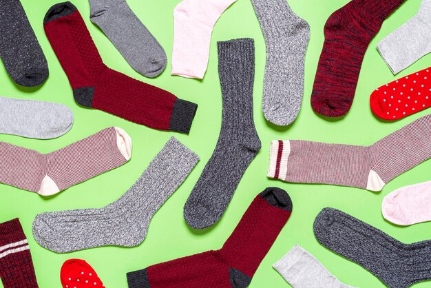 Photo many socks on a green background above view pattern with multicolored socks